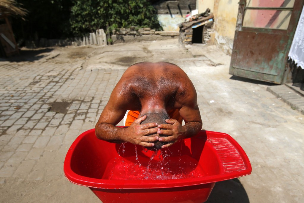 Homem se refresca como pode na Hungria em meio a onda de calor que atingiu a Europa no verão de 2013. Esse tipo de fenômeno pode ser cada vez mais frequente (Crédito: REUTERS/Laszlo Balogh)