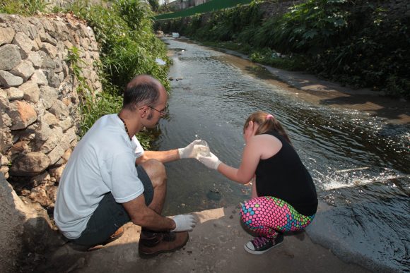 Cesar Pegoraro e Isabelle Aguiar Coelhas coletam água do Córrego do Sapé. Crédito: Felipe Rau / Estadão
