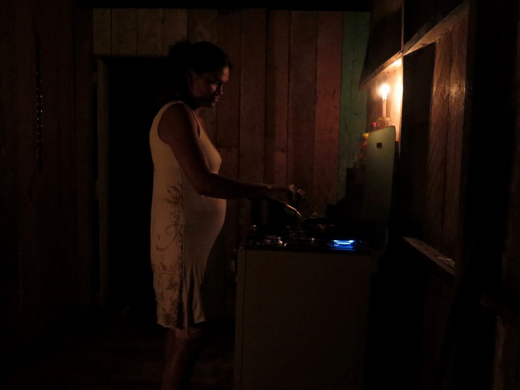 Sem luz, Gerlândia improvisa com as velas para continuar a preparar o jantar.