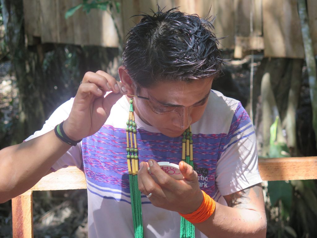 Índio Yawanawa se pinta com jenipapo na aldeia Mutum